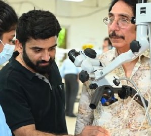 Dr Bhushan Kathuria guiding surgeons at a microscope during a temporal bone workshop