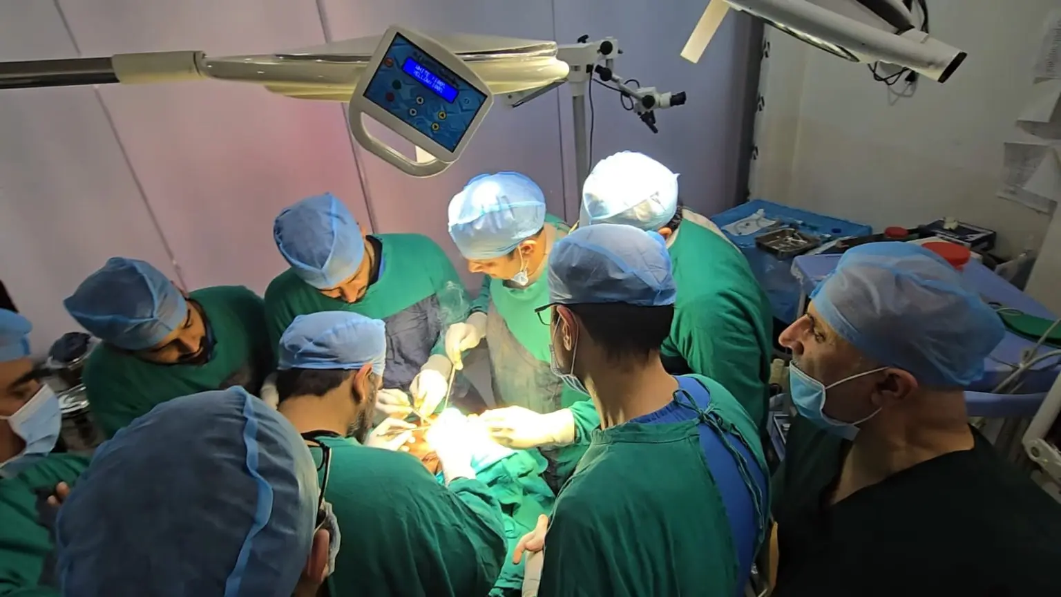 Surgeons and trainees gathered around an operative demonstration